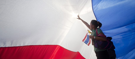 A pro-government supporter props up a giant Thai national flag during a rally at the Victory Monument in Bangkok April 25, 2010. The Thai capital braced on Sunday for more unrest after the government rejected a peace overture from anti-government protesters offering to end increasingly violent protests in return for early polls. REUTERS/Vivek Prakash (THAILAND - Tags: POLITICS CIVIL UNREST IMAGES OF THE DAY)