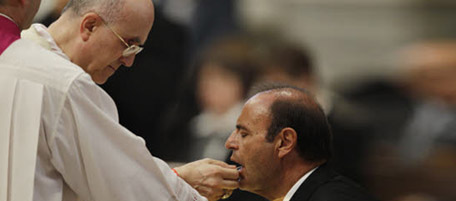 Vatican Secretary of State Cardinal Tarcisio Bertone gives the communion to RAI journalist Bruno Vespa during a mass to mark the 50th anniversary of his ministry, in St. Peter's Basilica, at the Vatican, Tuesday, July 6, 2010. (AP Photo/Alessandra Tarantino)