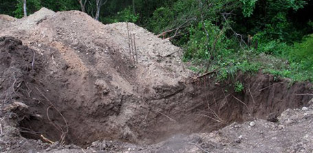 The area where at least 51 corpses have been found in two days of digging by investigators is seen in a field near a trash dump on the outskirts of the northern city of Monterrey, Mexico, Friday July 23, 2010. Excavations continue at one of the largest clandestine body dumping grounds in Mexico's drug war. (AP Photo/Iram Oviedo)