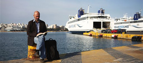 A man reads a book next to his luggage in front of parked ferries at the port of Piraeus, near Athens, Greece, on Thursday, May 20, 2010. Greek workers held a general strike against the government's austerity measures Thursday, two weeks after the previous day of protests deteriorated into rioting in which three people died in a burning bank. Ferries stayed tied up at port, buses, the Athens metro and trains suspended services, and many banks were closed. Schools shut down while public hospitals were working with emergency staffing levels. (AP Photo/Petros Giannakouris)