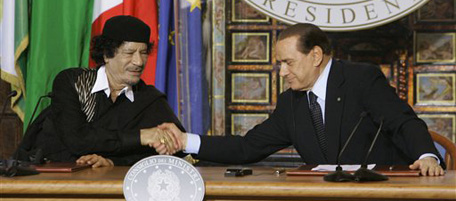 Libyan leader Moammar Gadhafi, left, and Italian Premier Silvio Berlusconi shake their hands at the end of a press conference at Rome's Villa Madama, Wednesday, June 10, 2009. Gadhafi is on a three-day official visit to Italy. (AP Photo/Pier Paolo Cito)