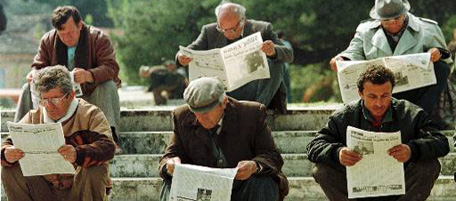 Albanians are eagerly reading the morning papers in a park of the insurgent town of Vlora, Friday morning, April 18, 1997. The town, in opposition to Albania's president Sali Berisha, is expecting Greek and Italian troops to secure international aid delivery. (AP Photo/Diether Endlicher)
