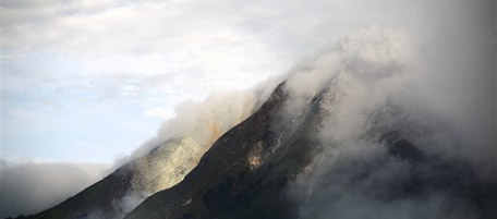Mount Sinabung spews volcanic smoke in Karo, North Sumatra, Indonesia, Sunday, Aug. 29, 2010. The volcano spewed hot lava and sand high into the sky early Sunday in its first eruption in 400 years causing thousands of people living around its slope to evacuate their homes. (AP Photo/Binsar Bakkara)