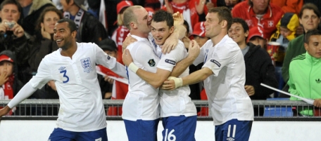 England's players with Ashley Cole, left, Wayne Rooney, 2nd left, and James Milner, right congratulate Adam Johnson, 2nd right, after he scored during the Euro 2012 group G qualification soccer match between Switzerland and England at the St. Jakob-Park Stadium in Basel, Switzerland, Tuesday, Sept. 7, 2010. (AP Photo/Keystone/Georgios Kefalas)