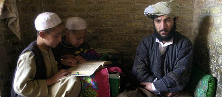 Abdol Mannan Mohammadi, teacher of the Quran, the Muslims holy book, listens to his students reading the Quran in Quranic school in Jame'e Mosque in Herat city in Afghanistan, Thursday Nov. 22, 2001. All children go to Quranic schools in Afghanistan when regular schools are closed for winter break which runs from November until January. (AP Photo/Hasan Sarbakhshian)