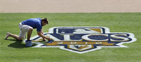 Texas Rangers grounds crew employee Don Crymes puts the final touches on the AL championship sereis logo at Texas Rangers Ballpark in Arlington, Texas, Wednesday, Oct. 13, 2010, in Arlington. The Rangers will host the New York Yankees on Friday and Saturday in the first two games of the series. (AP Photo/Tony Gutierrez)
