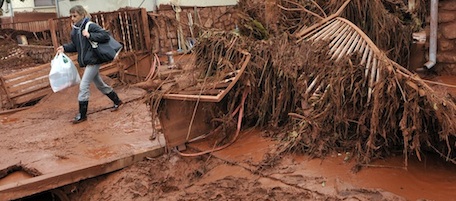 A villager saves belongings from her home flooded by toxic mud in the Kolontar, Hungary, Tuesday, Oct. 5, 2010. Monday's flooding was caused by the rupture of a red sludge reservoir at an alumina plant in western Hungary and has affected seven towns near Ajkai, 100 miles (160 kilometers) southwest of Budapest. The flood of toxic mud killed killed a yet unknown number of people, injured more than hundred, while some are still missing. (AP Photo/Bela Szandelszky)