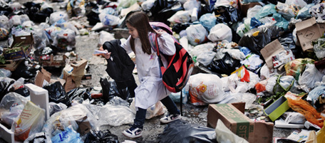 A child walks through uncollected garbage on his way back from school in the historic Spanish district of Naples on November 22, 2010. As piles of malodorous garbage continued to accumulate in the streets of Naples, the total amount of uncollected waste in the city was likely to reach 3,600 tons by the end of the day, the Italian press said. AFP PHOTO / ROBERTO SALOMONE