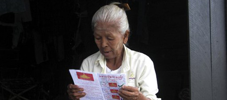 In this photo taken Thursday, Oct. 21, 2010, an elderly Myanmar woman looks at a leaflet handed out by the National Democratic Force party, formed by former members of pro-democracy leader Aung San Suu Kyi's National League for Democracy (NLD) in Yangon, Myanmar. General elections are scheduled for Nov. 7, the first since 1990. (AP Photo/Khin Maung Win)