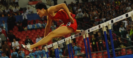Liu Xiang of China takes the final before finishing first and taking gold in the men's 110m hurdles final in the athletics competition at the 16th Asian Games in Guangzhou on November 24, 2010. Superstar Liu Xiang stormed to victory in the men's 110 metres hurdles, winning his third successive Asian Games gold to the delight of China's watching millions. AFP PHOTO / PETER PARKS (Photo credit should read PETER PARKS/AFP/Getty Images)