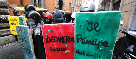 Students, holding shields with titles of books written on them, face police in a tiny street downtown Rome on November 24, 2010. Some 2000 students took to the streets to protest a reform of the university system and budget cuts decided by Prime Minister Silvio Berlusconi's government. AFP PHOTO / ALBERTO PIZZOLI (Photo credit should read ALBERTO PIZZOLI/AFP/Getty Images)