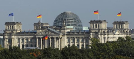 BERLIN - OCTOBER 03: German flags flutter over the Reichstag, seat of Germany's federal parliament, on the day of celebrations marking the 20th anniversary of German reunification on October 3, 2010 in Berlin, Germany. Germany is marking 20 years since the1990 reunification of East and West Germany following the collapse of the East German communist government one year before with concerts, outdoor amusements and fireworks. (Photo by Sean Gallup/Getty Images)
