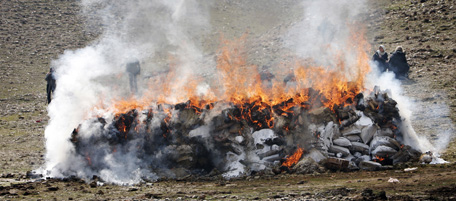 Afghans watch as authorities burn 16 tonnes of narcotics on the outskirts of capital Kabul on March 4, 2010. A stash including heroin, morphine, hashish and different types of chemical liquids used for drug production was incinerated by police in Kabul. Some 92 percent of the world's opium comes from Afghanistan, making the country the world's biggest supplier, a UN report released last year said. AFP PHOTO/BEHROUZ MEHRI (Photo credit should read BEHROUZ MEHRI/AFP/Getty Images)