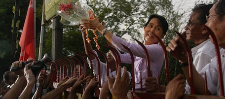 MYANMAR OUT - Myanmar's detained opposition leader Aung San Suu Kyi holds a bouquet of flowers as she appears at the gate of her house after her release in Yangon on November 13, 2010. Myanmar's democracy leader Aung San Suu Kyi walked free from the lakeside home that has been her prison for most of the past two decades, to the delight of huge crowds of waiting supporters. Waving and smiling, the petite but indomitable Nobel Peace Prize winner appeared outside the crumbling mansion where she had been locked up by the military junta for 15 of the past 21 years. AFP PHOTO/Soe Than WIN (Photo credit should read Soe Than WIN/AFP/Getty Images)
