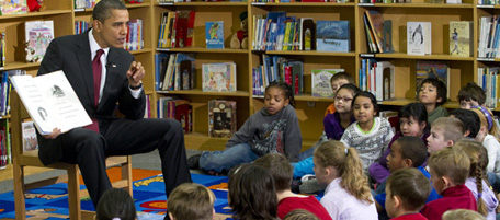 US President Barack Obama reads the book, "Twas the Night Before Christmas,"to students at Long Branch Elementary School in Arlington, Virginia, December 17, 2010, in a surprise visit to the suburban Washington elementary school. AFP PHOTO / Saul LOEB (Photo credit should read SAUL LOEB/AFP/Getty Images)