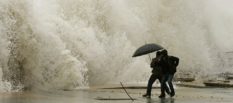 Lebanese men react as waves crash into a seaside promenade in the southern city of Sidon on December 12, 2010. Winds, rain and hail battered the eastern Mediterranean for a second day, killing at least four people and wreaking havoc as a months-long drought came to a sudden, drastic end. AFP PHOTO/MAHMOUD ZAYAT (Photo credit should read MAHMOUD ZAYAT/AFP/Getty Images)