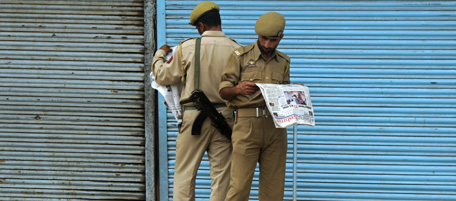 Indian paramilitary troopers read newspapers as they stand in a street of curfew bound Srinagar on August 4, 2010. Five more demonstrators died in Indian Kashmir as new protests erupted in defiance of pleas for calm from the region's chief minister, the deaths again brought huge crowds chanting anti-India slogans on to the streets of Srinagar as the bodies of two dead men were carried on stretchers to their funerals.. The death in early June of a 17-year-old student -- killed by a police tear-gas shell -- set off the series of almost daily protests during which scores of people have been killed, 27 of them since July 30. At least 44 people have died in the weeks of unrest -- most of them killed by security forces trying to disperse angry protests against Indian rule. AFP PHOTO/Tauseef MUSTAFA (Photo credit should read TAUSEEF MUSTAFA/AFP/Getty Images)