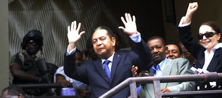 Former Haitian dictator Jean-Claude "Baby Doc" Duvalier is escorted January 18 2011 by police in the Karibe Hotel in Port-au-Prince. Police took Duvalier from his hotel Tuesday and headed to the prosecutor's office, witnesses said Tuesday. The ousted president, who made a surprise return to Haiti late Sunday, had been questioned for more than an hour in his room at the Hotel Karibe by the nation's chief prosecutor and a judge. He was then escorted by police down through the hotel lobby, but was not handcuffed. The head of the Port-au-Prince bar association, Gervais Charles, told AFP: "He is being taken to the prosecutors' office to notify him of the file against him." AFP PHOTO / Thony BELIZAIRE. (Photo credit should read THONY BELIZAIRE/AFP/Getty Images)