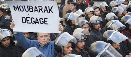 A protestor holding a placard in French reading "Mubarak, get out", is surrounded by riot police during a demonstration in downtown Cairo, Egypt Tuesday, Jan. 25, 2011. Anti-government protesters marched in the Egyptian capital chanting against President Hosni Mubarak and calling for an end to poverty. (AP Photo/Mohammed Abu Zaid)