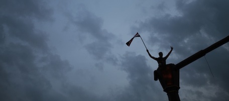 A protester waves an Egyptian flag after he climbed on a lampost during a demonstration in Tahrir square in downtown Cairo, Egypt, Sunday, Jan. 30, 2011. (AP Photo/Lefteris Pitarakis)