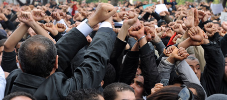 Tunisian demonstrators hold up their hands as if they are handcuffed on January 14, 2011 and shout slogans demanding the departure of President Zine El Abidine Ben Ali, in front the Interior ministry on Tunis' Habib Bourguiba avenue a day after the President's address to the nation. Police threw up a barricade to stop the march from reaching the interior ministry, blamed for a harsh crackdown on protests that a rights group says has killed 66 people, several times higher than the official toll. AFP PHOTO / FETHI BELAID (Photo credit should read FETHI BELAID/AFP/Getty Images)