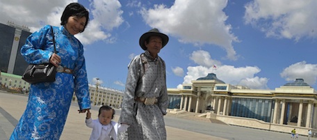 A Mongolian couple dressed in traditional costumes with their child walk at the square in Ulan Bator on July 6, 2008. Mongolia has lifted the state of emergency imposed after deadly election riots hit the capital Ulan Bator, with the president July 6 appealing for calm amid lingering fears of further violence. AFP PHOTO/TEH Eng Koon (Photo credit should read TEH ENG KOON/AFP/Getty Images)