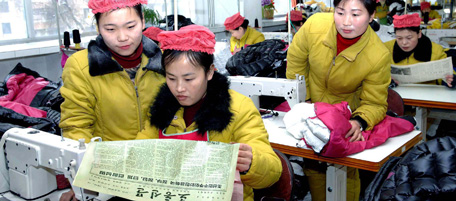 This January 6, 2011 picture released by North Korea's Central News Agency shows workers at clothes factory reading the newspaper's article offering proposal for peace and reunifications on the Korean Peninsula by North Korean government, political parties and organizations. HANDOUT RESTRICTED TO EDITORIAL USE AND EDITORIAL SALES - MANDATORY CREDIT AFP PHOTO / KNS-KCNA (Photo credit should read KNS/AFP/Getty Images)