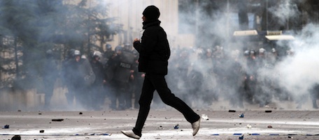 A protester runs after clashes with police during an anti-government protest in Tirana on January 21, 2011. Albanian anti-government protesters clashed with police when demonstrators threw stones at the security forces who responded with tear gas. Several thousand people gathered in the capital on January 21 after a call from the socialist opposition to protest against the current government of Prime Minister Sali Berisha. Three people were shot dead during an anti-government protest in Tirana on Friday, Sami Koceku, head of the military hospital emergency services told AFP. AFP PHOTO / GENT SHKULLAKU (Photo credit should read GENT SHKULLAKU/AFP/Getty Images)