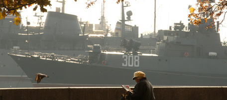 A woman reads a book on the embankment as a military ship is docked in Kronshtadt, near Saint-Petersburg on October 9, 2010. AFP PHOTO / KIRILL KUDRYAVTSEV (Photo credit should read KIRILL KUDRYAVTSEV/AFP/Getty Images)