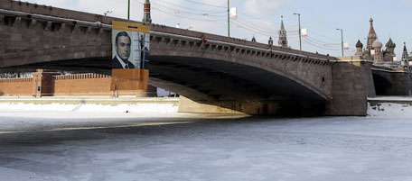 A poster denouncing Russian Prime Minister Vladimir Putin and supporting jailed tycoon Mikhail Khodorkovsky hangs from a bridge near the Kremlin in Moscow, Russia, Sunday, Feb. 20, 2011. The poster shows Putin behind bars and the slogan "It's time to change." (AP Photo/Ivan Sekretarev)