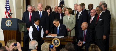 US President Barack Obama, surrounded by lawmakers, signs the healthcare insurance reform legislation during a ceremony in the East Room of the White House in Washington, DC, March 23, 2010. Obama Tuesday signed into law sweeping reforms that will for the first time ensure health care coverage for almost every American. AFP PHOTO / Saul LOEB (Photo credit should read SAUL LOEB/AFP/Getty Images)