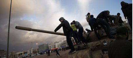 Libyans stand atop an army tank outside the court house in the eastern dissident-held city of Benghazi on February 24, 2011 amid political turmoil and an insurrection against Moamer Kadhafi's regime. AFP PHOTO/GIANLUIGI GUERCIA (Photo credit should read GIANLUIGI GUERCIA/AFP/Getty Images)