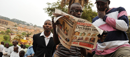 People read a newspaper while waiting in line at a polling station in Uganda's capital Kampala on February 18, 2011 to vote in presidential and parliamentary elections. Some 14 million voters started voting on February 18 in polls widely predicted to return long-time leader Yoweri Museveni to power, with a fragmented opposition crying foul even before the ballot. AFP PHOTO / ROBERTO SCHMIDT (Photo credit should read ROBERTO SCHMIDT/AFP/Getty Images)
