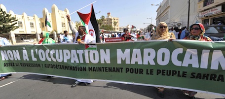 Protesters walk behind a banner reading ' We refuse Occupation of Western Sahara by Morocco' as they take part in a march marking the start of the annual World Social Forum on February 6, 2011 in Dakar. Some 10,000 people marched through Dakar, marking the start of the annual World Social Forum, an annual gathering of leftists taking place as popular protest and turmoil sweep the Arab world. AFP PHOTO / SEYLLOU (Photo credit should read SEYLLOU/AFP/Getty Images)