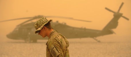 A US army soldier walks past a US army Blackhawk helicopter from Alpha Company 7-101 AVN during a sandstorm at FOB Wilson in Kandahar province in southern Afghanistan on March 27, 2011. Around 140,000 foreign troops are deployed in Afghanistan within the UN-mandated, NATO-led, International Security Assistance Force (ISAF) and the US-led coalition Operation Enduring Freedom, which overthrew the Taliban in late 2001. AFP PHOTO/Peter PARKS (Photo credit should read PETER PARKS/AFP/Getty Images)