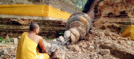 A Thai Buddhist monk inspects a fallen stupa of the Chedi Luang pagoda a day after a strong earthquake struck Myanmar near the Thai border, in the Chiang Saen district of Thailand's northern Chiang Rai province on March 25, 2011. More than 60 people were killed and 90 injured after a strong 6.8 magnitude earthquake struck Myanmar near its border with Thailand, an official said. AFP PHOTO (Photo credit should read STR/AFP/Getty Images)