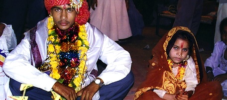 INDORE, INDIA: A 16 year old boy (L) waits to be married to a much younger girl (R) during a mass child marriage ceremony in Indore, 15 May 2002 some 200 kms west of the Madhya Pradesh state capital city Bhopal. At least 140 children aged 4 to 17 years took part in mass wedding ceremonies despite a government ban on under-age nuptials. (FILM) AFP PHOTO (Photo credit should read AFP/Getty Images)