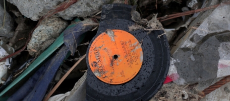 RIKUZENTAKATA, JAPAN - MARCH 20: A broken record is seen amongst the rubble on March 21, 2011 in Rikuzentakata, Japan. The 9.0 magnitude strong earthquake struck offshore on March 11 at 2:46pm local time, triggering a tsunami wave of up to ten metres which engulfed large parts of north-eastern Japan, and also damaging the Fukushima nuclear plant and threatening a nuclear catastrophe. The death toll continues to rise with numbers of dead and missing exceeding 20,000 in a tragedy not seen since World War II in Japan. (Photo by Chris McGrath/Getty Images)