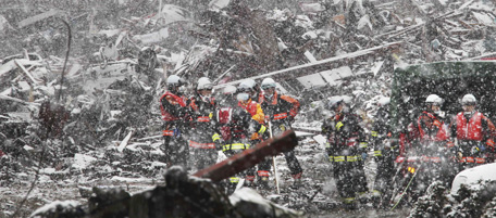 Braving snow, rescue workers search for survivors in the rubble of tsunami-stricken town of Minamisanriku in Miyagi Prefecture Wednesday, March 16, 2011, five days after a devastating earthquake and tsunami slammed northeastern Japan. (AP Photo/The Yomiuri Shimbun, Hiroaki Ohno) JAPAN OUT, MANDATORY CREDIT