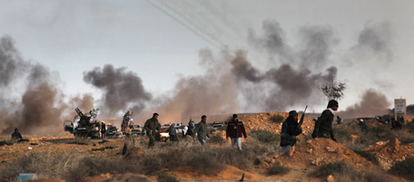 RAS LANUF, LIBYA - MARCH 09: Rebel fighters advance on the frontline as rebel Katusha rockets fly overhead towards government positions on March 9, 2011 near Ras Lanuf, Libya. The rebels pushed back government forces loyal to Libyan leader Muammar Gaddafi towards Ben Jawat. (Photo by John Moore/Getty Images)