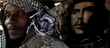 A Libyan rebel sits in his vehicle next to an image of Argentine-born Cuban revolutionary leader Ernesto "Che" Guevara, on the outskirts of the town of Bin Jawad on March 27, 2011 as rebels pushed westwards in hot pursuit of Moamer Kadhafi's forces, winning back control of the key Ras Lanuf oil site and pressing on towards Kadhafi's hometown of Sirte, a central coastal city. AFP PHOTO / ARIS MESSINIS (Photo credit should read ARIS MESSINIS/AFP/Getty Images)