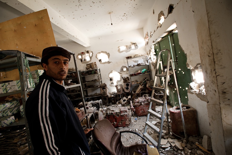 Un ribelle in un negozio crivellato di colpi e sfondato dai bombardamenti. Misurata, 16 aprile 2011. (PHIL MOORE/AFP/Getty Images)