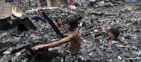 Residents look for recyclable materials among debris and rubbish after a fire gutted informal settlers overnight in Malabon City suburban Manila on April 7, 2011. Around a thousand residents were afftected by the fire, but no caualties were reported. AFP PHOTO/TED ALJIBE (Photo credit should read TED ALJIBE/AFP/Getty Images)