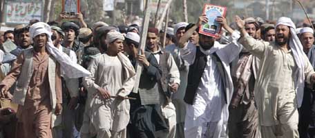 Afghan protestors hold copies of the Quran as they march during a demonstration to condemn the burning of a copy of the Muslim holy book by a Florida pastor, in Kandahar, Afghanistan on Saturday, April. 2, 2011. The governor's office in Kandahar has raised the death toll to nine in a Quran burning protest that turned violent in southern Afghanistan. (AP Photo/Allauddin Khan)