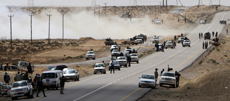 Libyan rebels take position near the eastern town of Brega on March 31, 2011 as street battles raged between them and forces loyal to Moamer Kadhafi who suffered a major blow with the defection of his foreign minister. AFP PHOTO/MAHMUD HAMS (Photo credit should read MAHMUD HAMS/AFP/Getty Images)