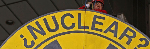 A Greenpeace activist hangs in back of an anti-nuclear sign in front of Mexico's Energy Secretariat (Sener) during a protest in Mexico City, Thursday March 31, 2011. The sign reads in Spanish, "Nuclear? No, Thanks!" (AP Photo/Alexandre Meneghini)