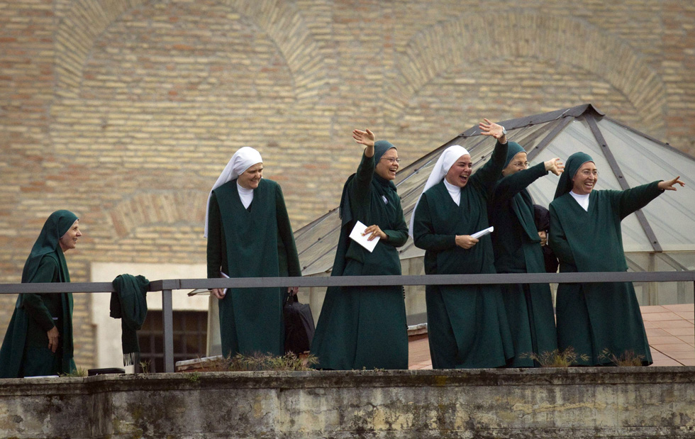 Un gruppetto di suore saluta la folla da un tetto che dà su piazza San Pietro. (AP Photo/Anja Niedringhaus)