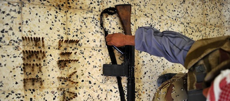 A Libyan rebel puts his weapon next to bullets reading "Free Libya" placed by rebels gathered at a house in Al-Ghiran near Misrata airport on May 1, 2011, hours before the house was hit by a mortar shell fired by Moamer Kadhafi's forces, killing two rebels and wounding five others. AFP PHOTO / CHRISTOPHE SIMON (Photo credit should read CHRISTOPHE SIMON/AFP/Getty Images)