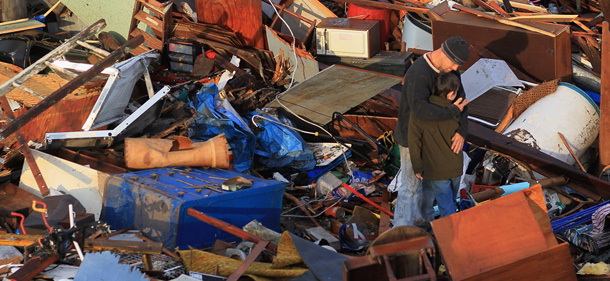 JOPLIN, MO - MAY 24: Ernie Darby hugs his son Davis Darby as they salvage what they can from their house after it was destroyed when a massive tornado passed through the town on May 24, 2011 in Joplin, Missouri. 116 people are known to have been killed and authorities expect the death toll to climb in the town of 50,000 people. Rescue workers are searching for survivors as the threat of further storms still looms. (Photo by Joe Raedle/Getty Images)