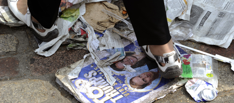 A person walks on a newspaper bearing a portrait of Britain's Prince William and Kate Middleton, during the royal wedding, on April 29, 2011, in central London. AFP PHOTO / ODD ANDERSEN (Photo credit should read ODD ANDERSEN/AFP/Getty Images)